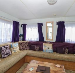 A living room with a sofa and coffee table at Whispering Meadows - 104, Hemsby