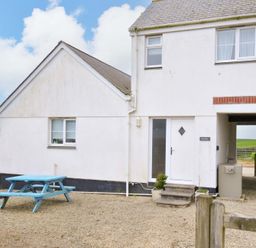 An outdoor view of a house with a picnic table at Cribba in Port Isaac