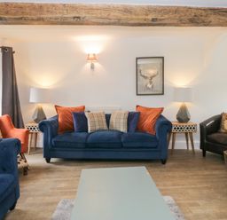 A living room with a blue sofa and a coffee table at No.2 The Flags in Grange-over-Sands