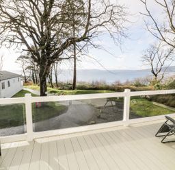 An outdoor area with decking and trees at Serenity Lodge in Wemyss Bay