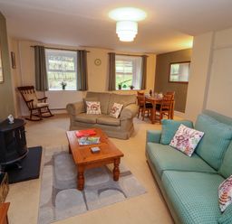 A living room with seating and a dining table at Easthwaite Cottage in Holmrook near Easthwaite Farm