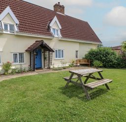A garden with a house and outdoor seating at Driftway Stables Retreat, Diss