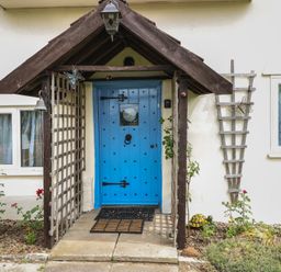 A blue door with a trellis next to it at Driftway Stables Retreat in Diss
