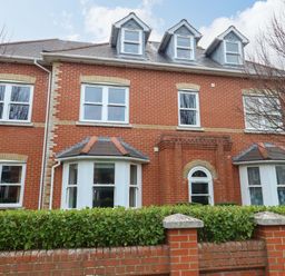 A house with multiple windows and a brick wall at Flat 7 Weymouth