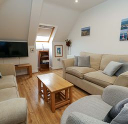 A living room with a sofa and television at Flat 7 in Weymouth