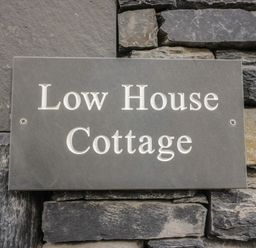 A nameplate on a stone wall at Low House Cottage in Ayside near Newby Bridge