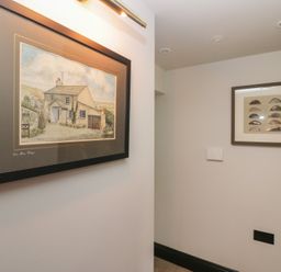A hallway with framed pictures on the walls at Low House Cottage Ayside near Newby Bridge