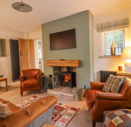 A living room with a fireplace and sofa at Bridge House Cottage Burn Bridge near Harrogate