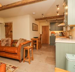 A kitchen with a sofa and dining area at Bridge House Cottage Burn Bridge near Harrogate