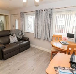 A living room with a sofa and table at Primrose Cottage in Chathill