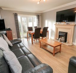 A living room with sofa and dining table at Megstone in Chathill