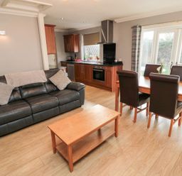 A living room with a sofa and dining area at Megstone in Chathill