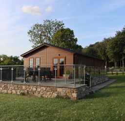A cabin with a deck and hot tub at Holly Lodge near Lloc in Caerwys