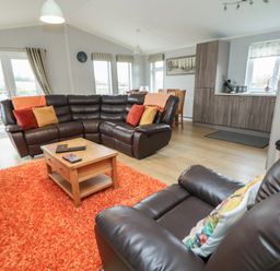 A living room with sofas and a coffee table at Pine Lodge in Lloc near Caerwys