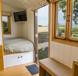 A bedroom with a bed and television at No 2 The Parkland in Upton Warren
