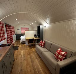 A living room with a sofa and dining area at The Lodge in Upton Warren