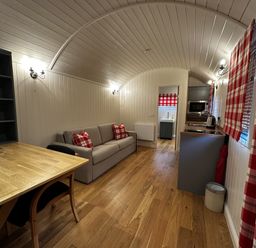A living room with a sofa and table at The Lodge in Upton Warren
