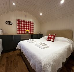 A bedroom with a bed and towels on it at The Lodge in Upton Warren