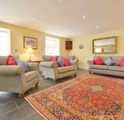 A living room with sofas and a rug at The Cider Barn at Home Farm Down Thomas near Wembury