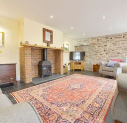 A living room with a fireplace and television at The Cider Barn at Home Farm Down Thomas near Wembury