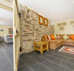 A living room with a sofa and coffee table at The Cider Barn at Home Farm Down Thomas near Wembury