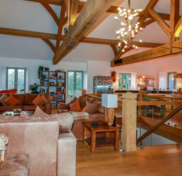 A living room with a sofa and bookshelf at Kerslake House in Crafthole