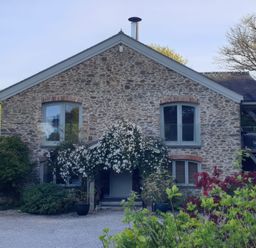 A stone house with windows and plants at Kerslake House in Crafthole