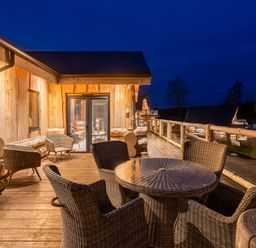 An outdoor deck area with a table and chairs at Bears Den in Addingham