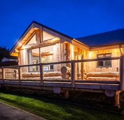 A wooden cabin with a deck and large windows at The Farmhouse in Addingham