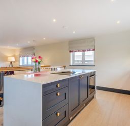 A kitchen with an island and cabinets at Bell House in Llanfechell