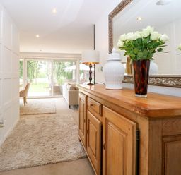 A hallway with a wooden table and flowers at Three Ways South Lopham near Garboldisham