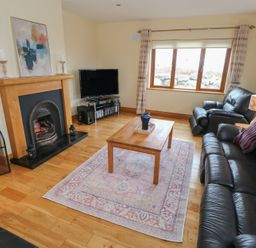 A living room with a fireplace and television at Tigh Marie 
