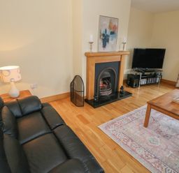 A living room with a sofa and fireplace at Tigh Marie