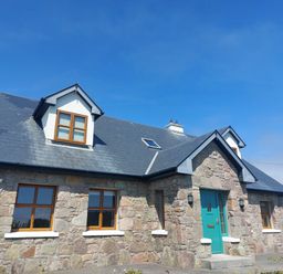 A house with a stone facade and teal door at Tigh Marie 