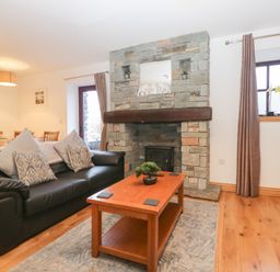 A living room with a fireplace and a coffee table at Newlands Cottage in Keswick