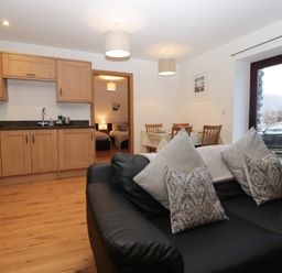A kitchen with a sofa and dining area at Newlands Cottage in Keswick