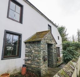 An outdoor stone entrance with plants at Birkbank Farm in Cockermouth