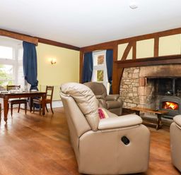 A living room with armchairs and a dining table at Dowrich West Wing Apartment in Crediton