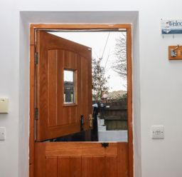 An entrance with a wooden door and welcome sign at The Old Telephone Exchange in Exeter