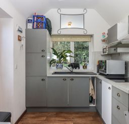 A kitchen with cabinets and a door at The Old Telephone Exchange in Exeter
