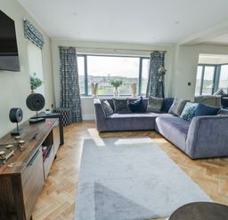A living room with a sofa and TV at Pengarnedd in Amlwch