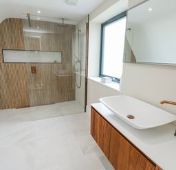 A bathroom with a glass shower and a sink at Pengarnedd in Amlwch