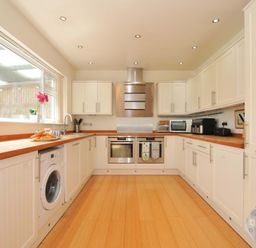 A kitchen with a washing machine and oven at Porthmeor in Wadebridge