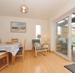 A dining room with a table and chairs at Porthmeor in Wadebridge
