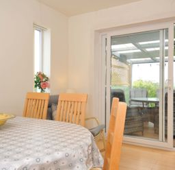 A dining room with a table and chairs at Porthmeor in Wadebridge