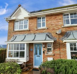 A house with a blue door and garden at Still Waters in Weymouth