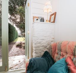 A seating area with a sofa and door leading to garden at Shades Farm Cabin Cirencester