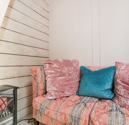 A sofa with cushions in a snug at Shades Farm Cabin in Cirencester