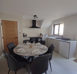 A kitchen with a dining table and chairs at Upper Longlands in Dawlish