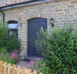 An entrance with plants and a wooden fence at Horse Gin in Parkend